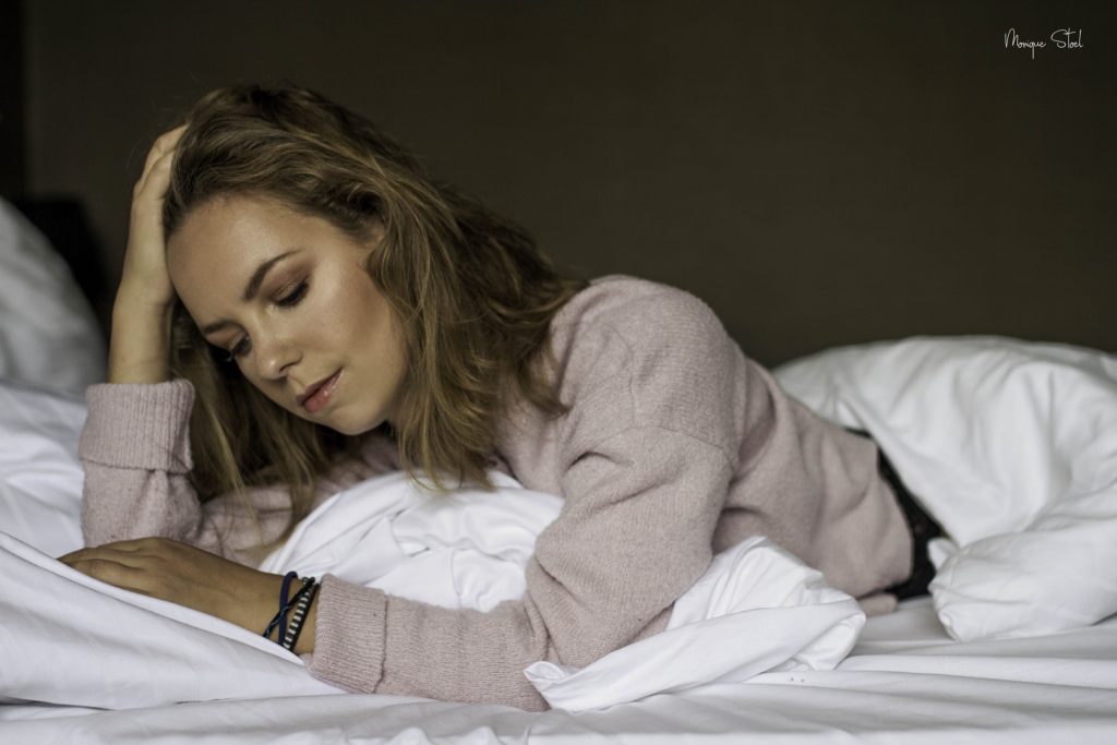 girl in bed wearing pink sweater